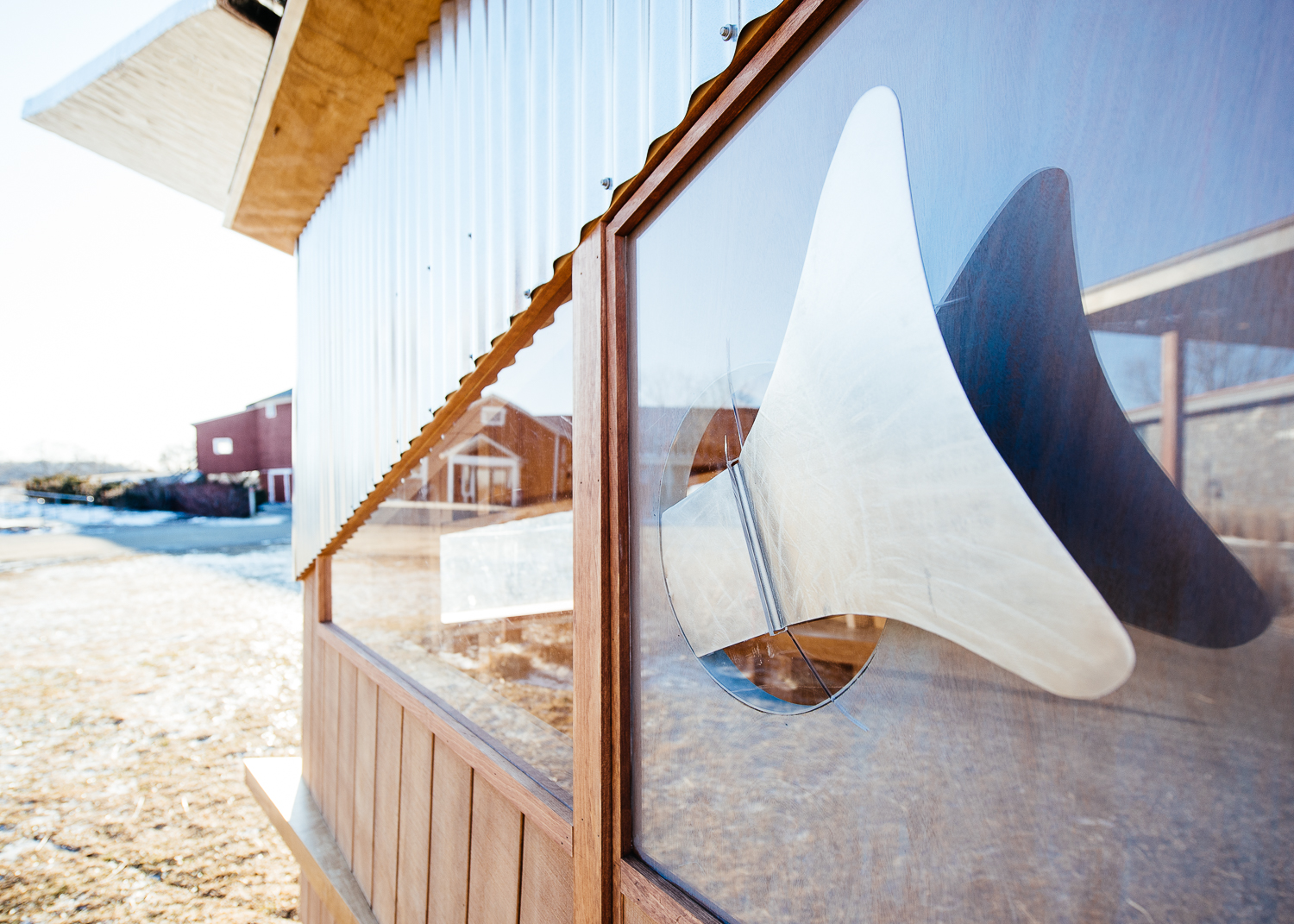 Detail of a metal fabricated fish breaking through the door.