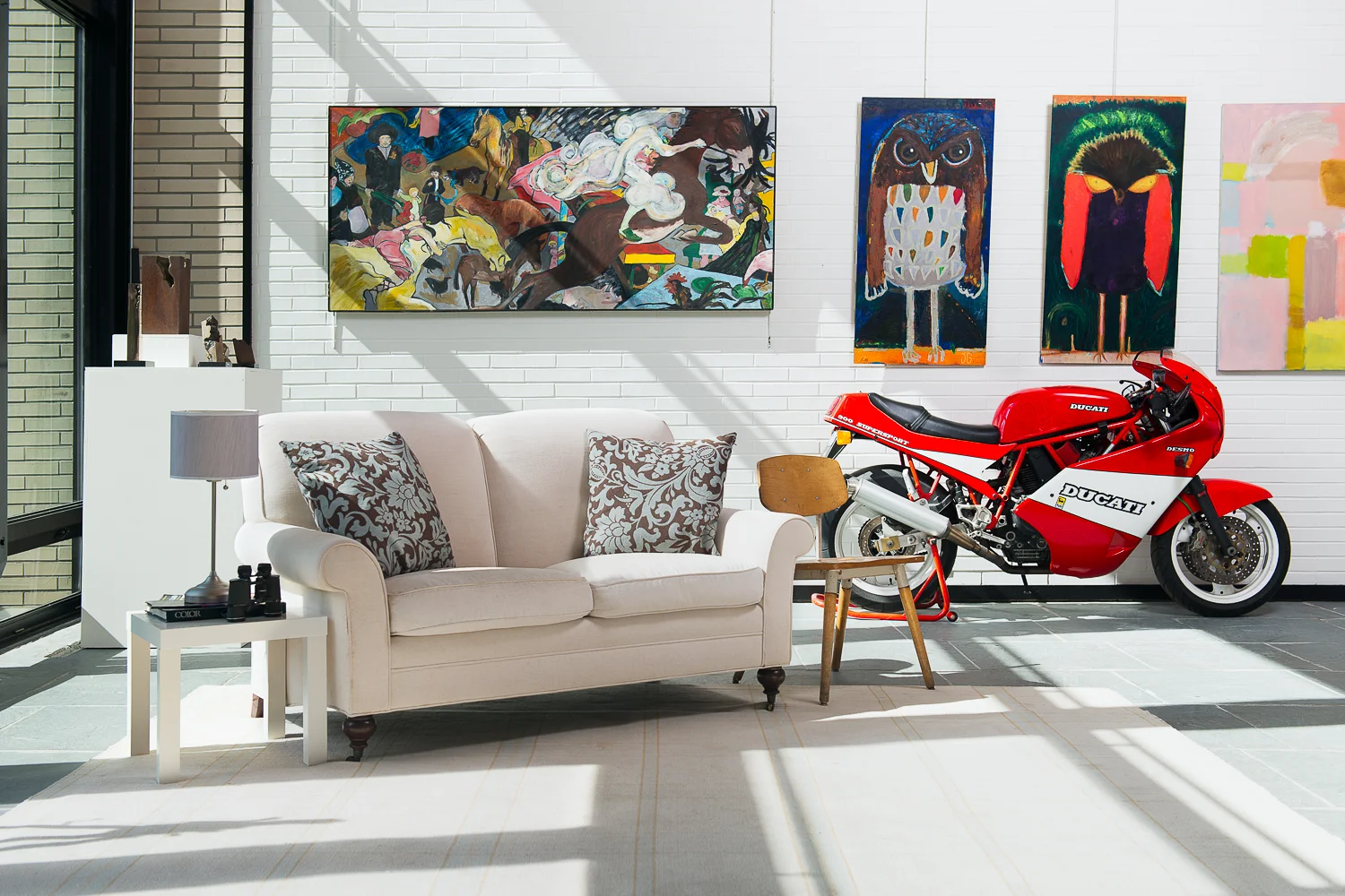 Paintings, sculptures, motorcycles and light fill the gallery space. 