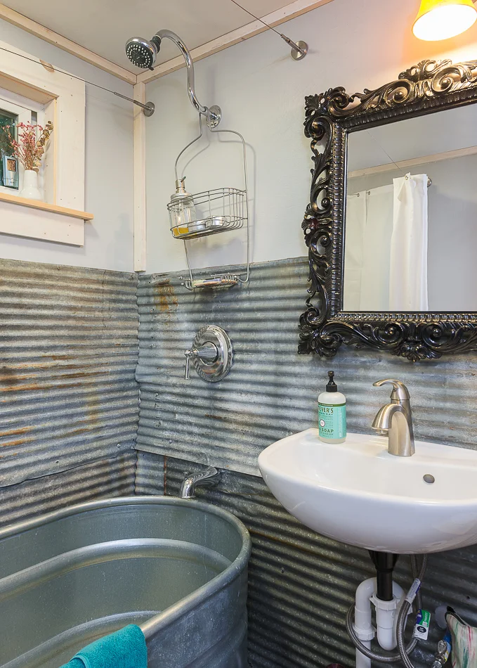 Bathroom with trough shower and old barn roofing was used for the walls. 