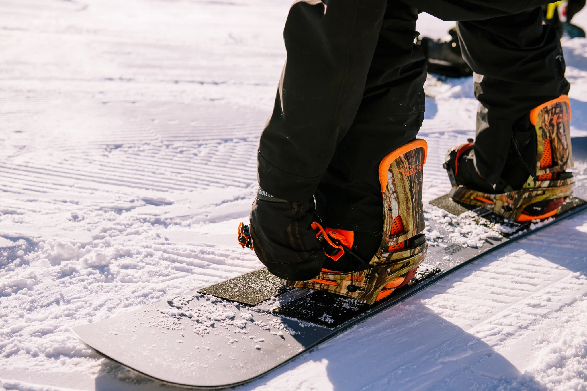 Snowboarder strapping in