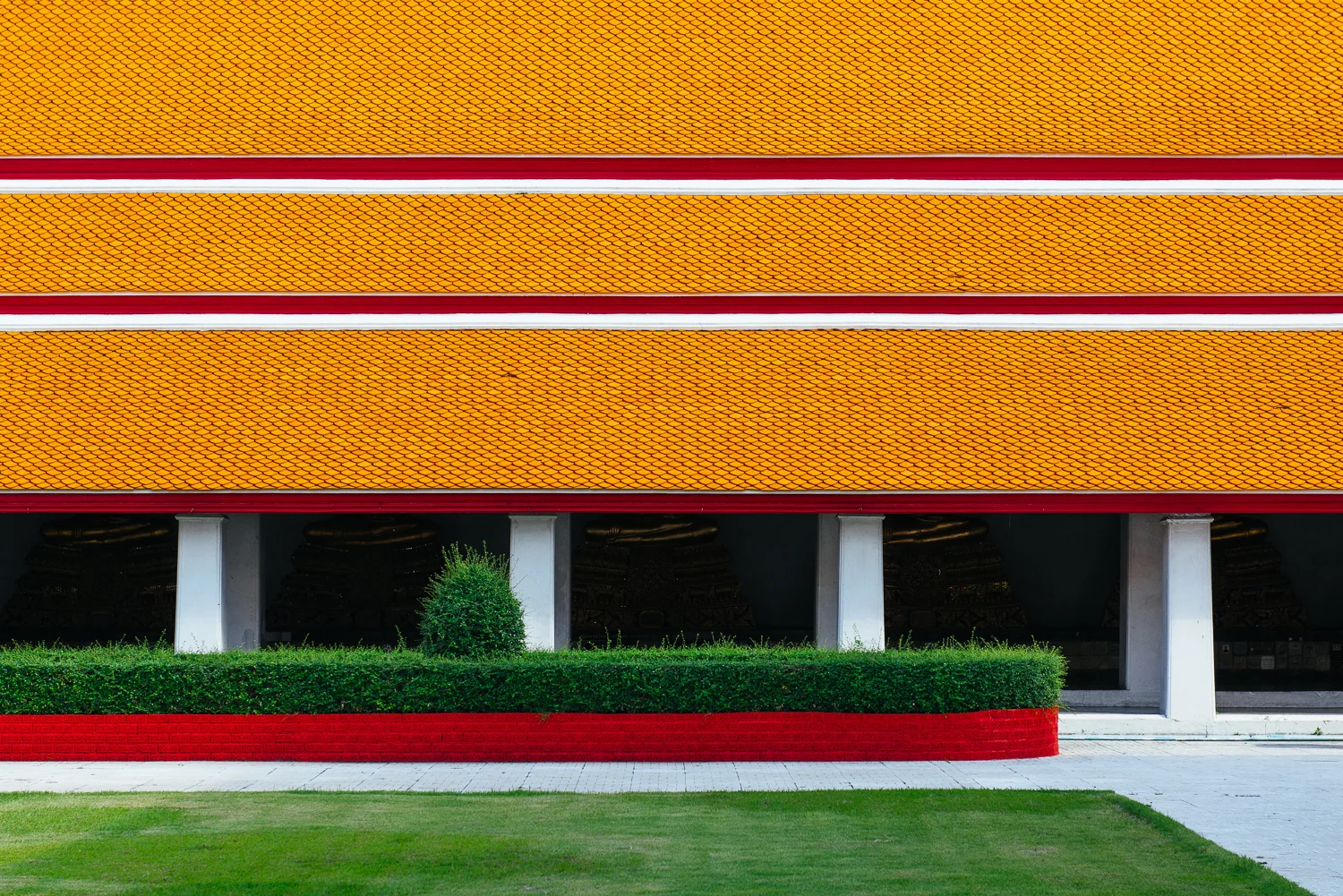 Ceramic roof tiles and the manicured lawn and hedges.