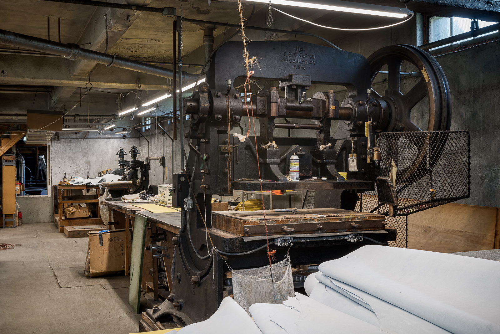 Industrial press is used to cut through multiple layers of fabric. Its original use was for cutting newspaper.