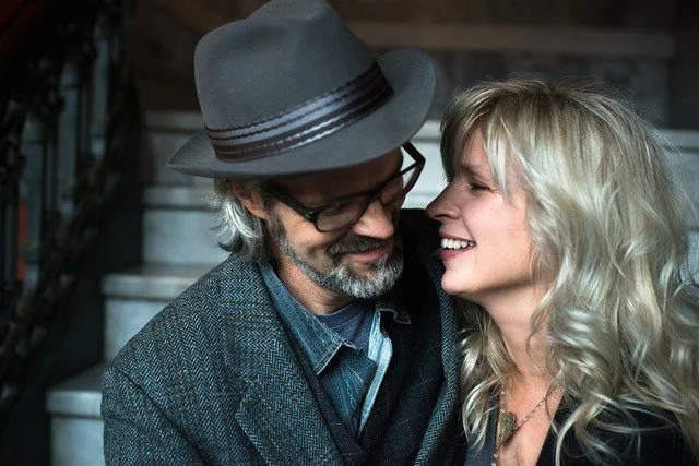 couple leaning in close with warm affection in front of a stairwell