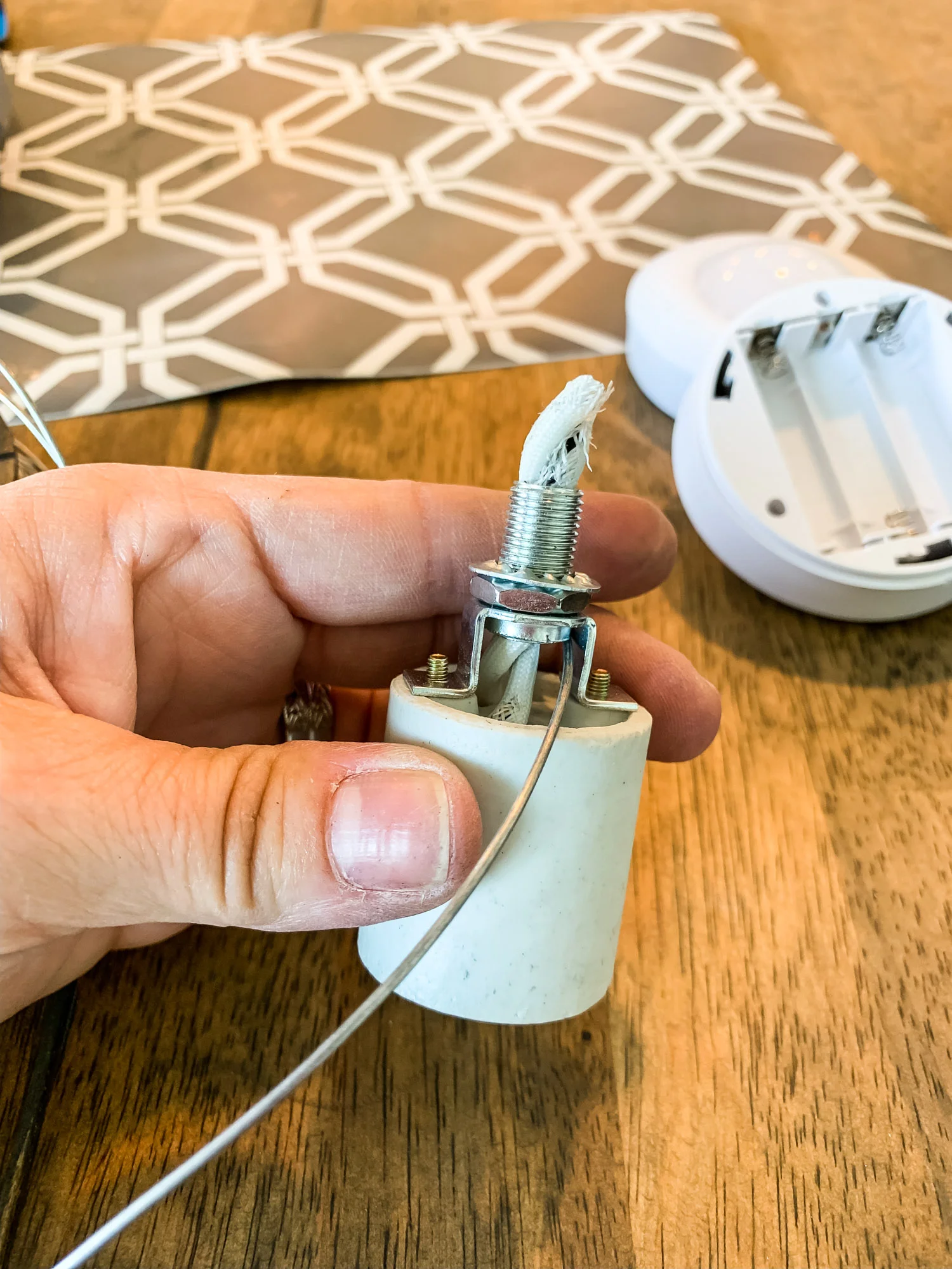 Thread flexible wiring through the top of the thing that holds the lightbulb and loop it around the bottom, where the lightbulb would go.