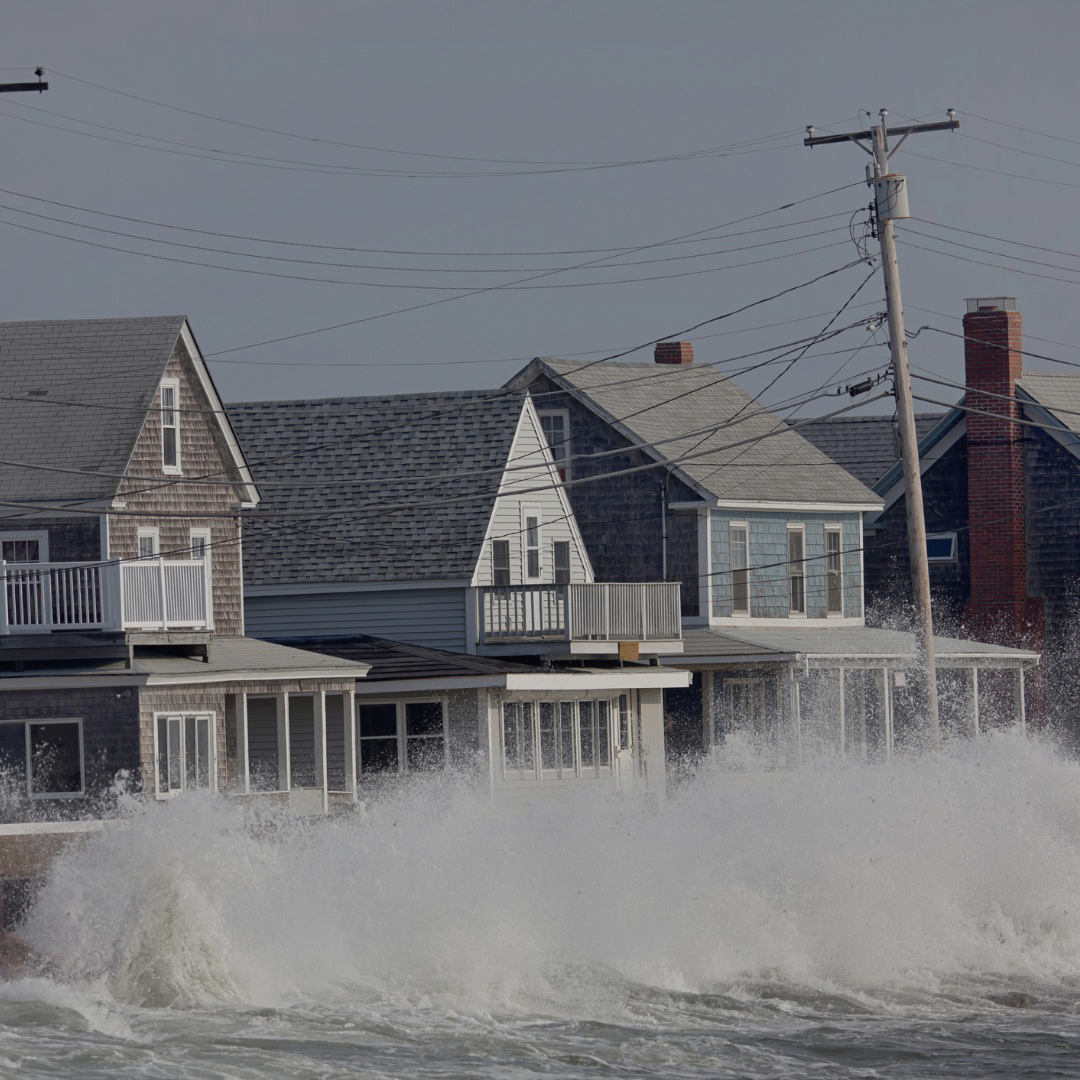 ocean-storm-waves-crashing-into-seawall-in-front-of-houses-picture-id184104610.png