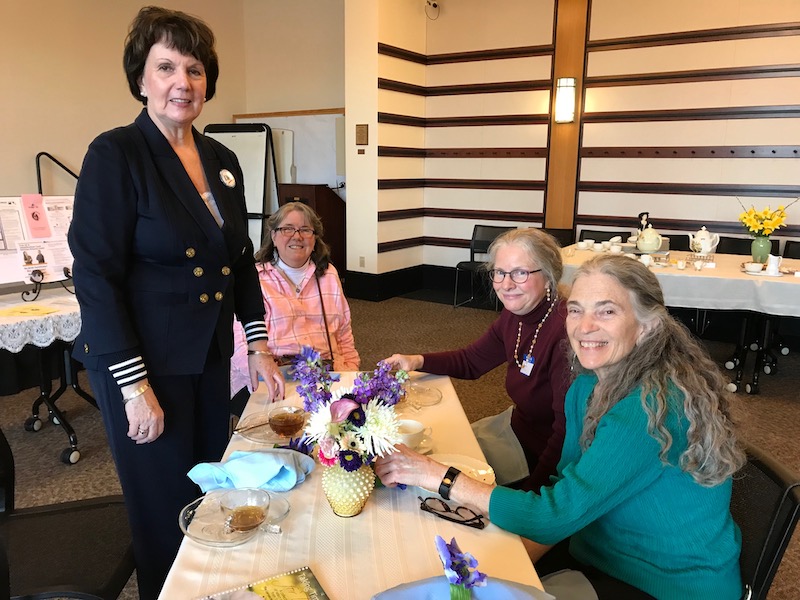 Volunteer coordinator Kathy Krusiek (standing) with guests enjoying high tea.
