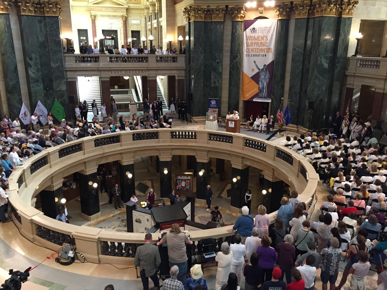  Justice Ann Walsh Bradley making closing remarks. The Wisconsin Historical Society’s exhibit is visible in the rotunda.  