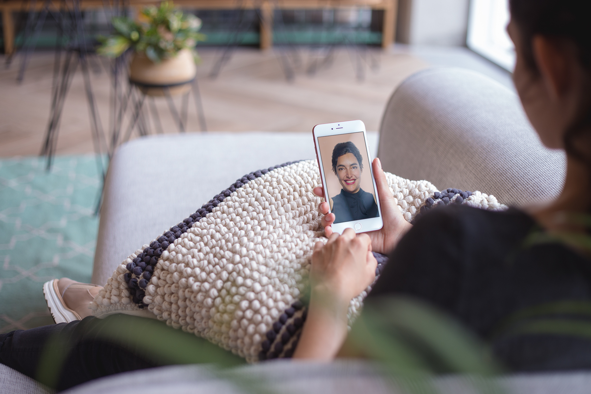 mockup-of-a-woman-using-a-rose-gold-iphone-sitting-on-a-sofa-a21283.png