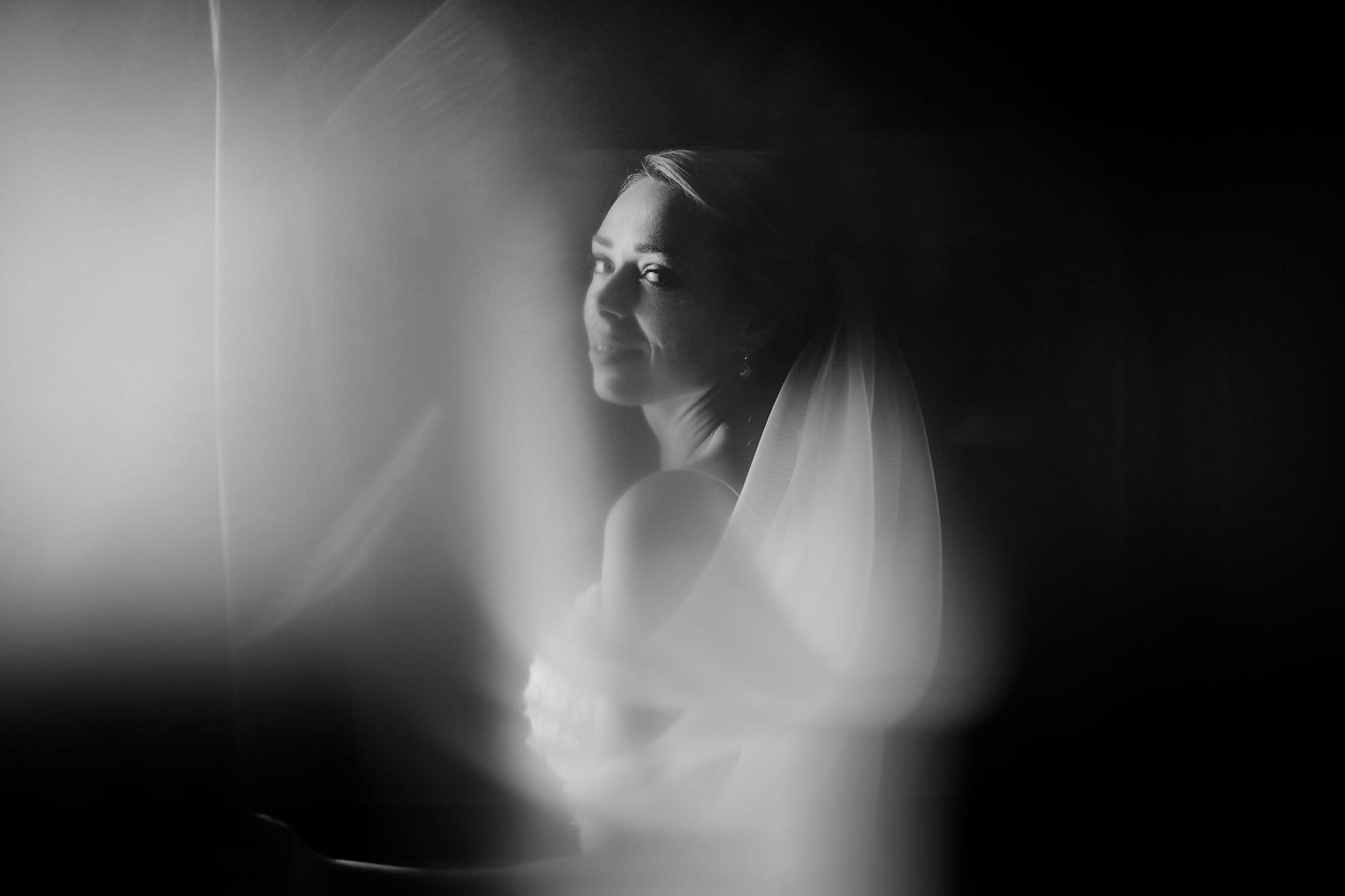 amsterdam trouwfotograaf  zwart en wit bruidsportret in raam met trouwjurk