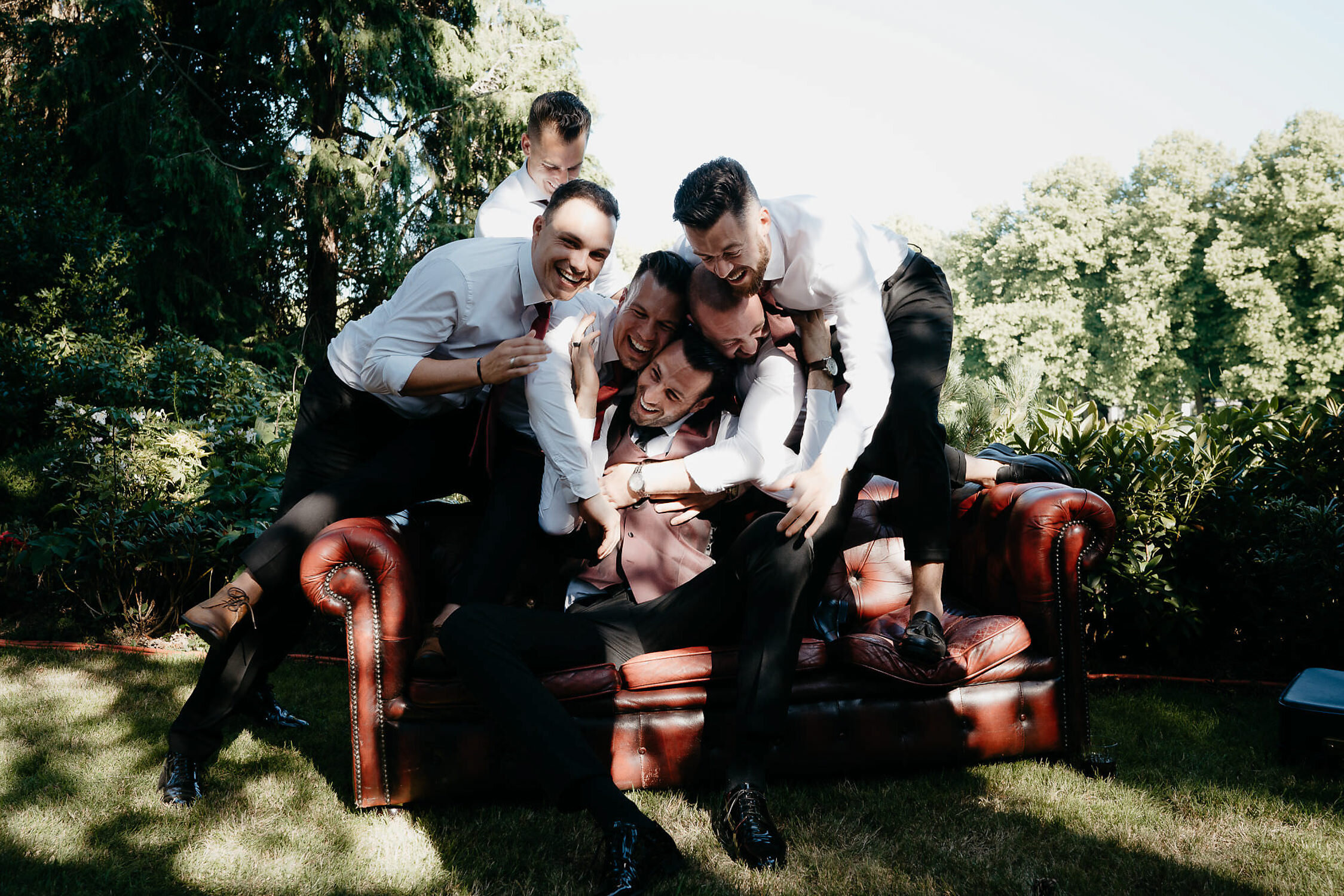 amsterdam wedding photography photo of the groom and groomsmen in the landscape on red sofa