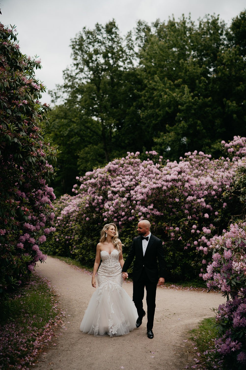 Couple walking through colourful gardens at Landgoed Rhederoord Wedding. Photographed by mark hadden amsterdam destination wedding photographer.