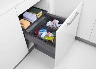 Meuble sous-évier équipé d‘un système pour déchets. Cadre télescopique raccourci avec conteneur à déchets muni d‘un dispositif de suspension. Nécessaire dans le cas où les raccords de construction ne peuvent pas être déplacés. 