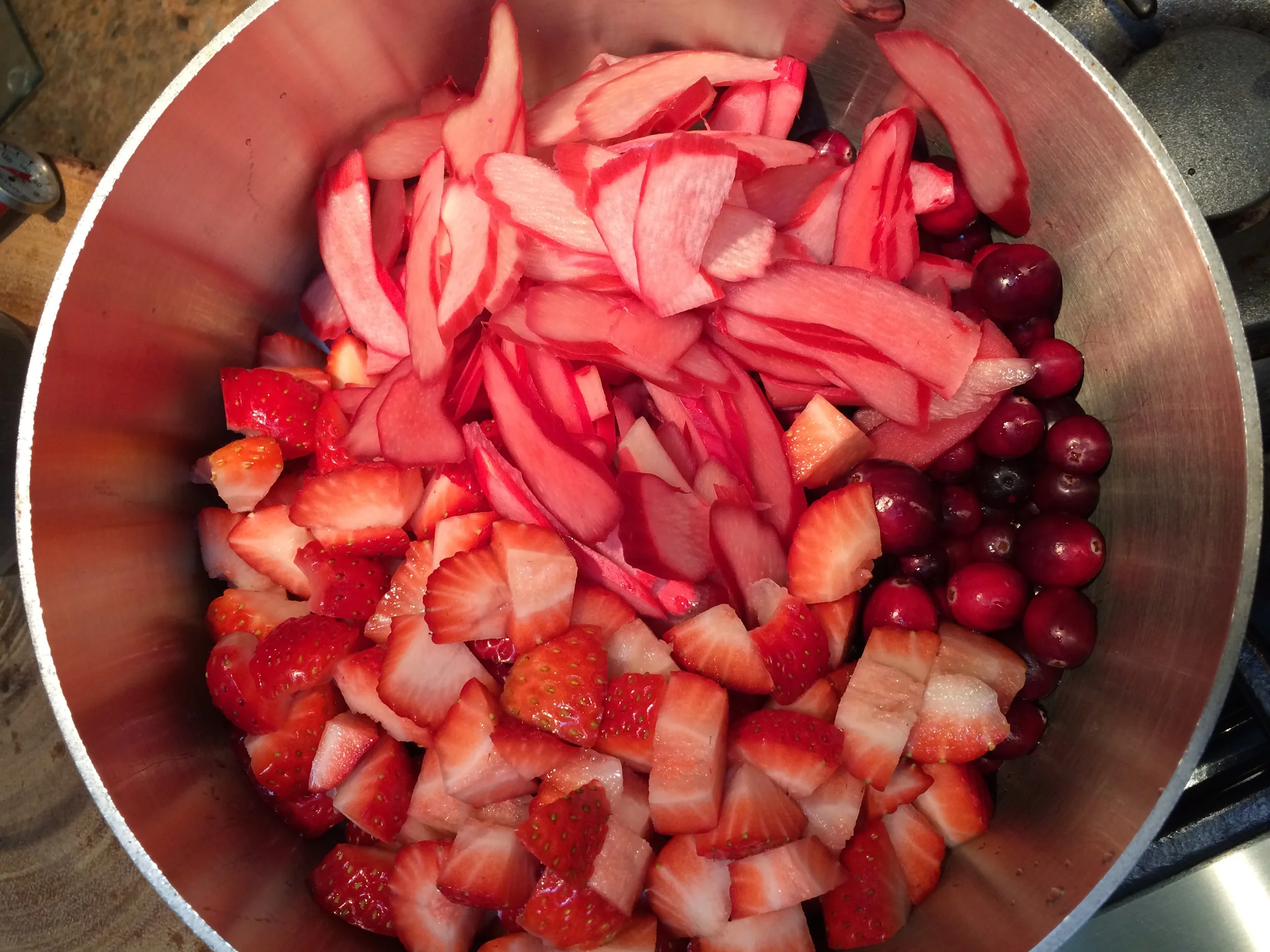 I cut the strawberries and rhubarb and put them in a medium-sized sauce pan with the cranberries, and 1/4 cup of the left-over orange zest sugar I had on-hand, along with the juice of one orange, it's zest and a cup of steeped Tazo Youthberry tea. (playing with flavors)