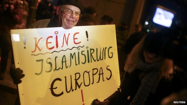 A German PEGIDA supporter holds a sign that reads, "No Islamization of Europe." 