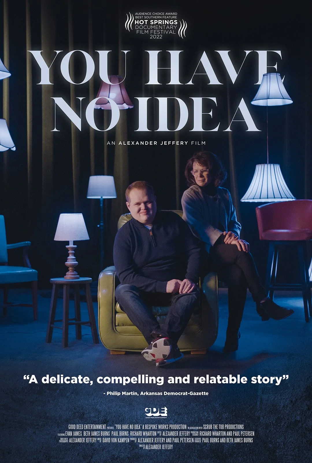 Poster for the film "You Have No Idea" featuring a young man sitting on a green couch with a woman sitting on its armrest, surrounded by various standing lamps, with the title and credits at the top and bottom.