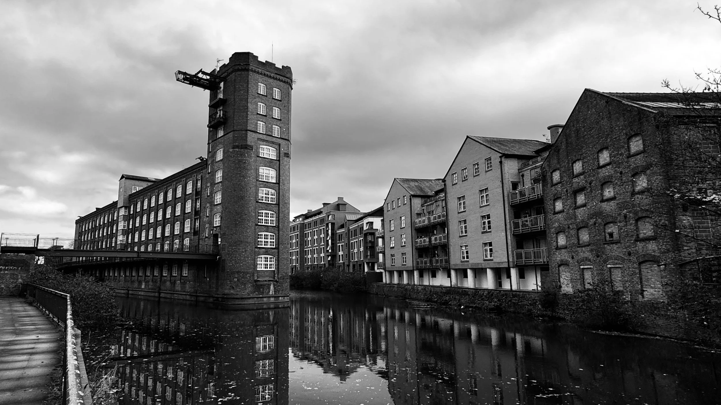 Former factories converted into flats above a canal-like river