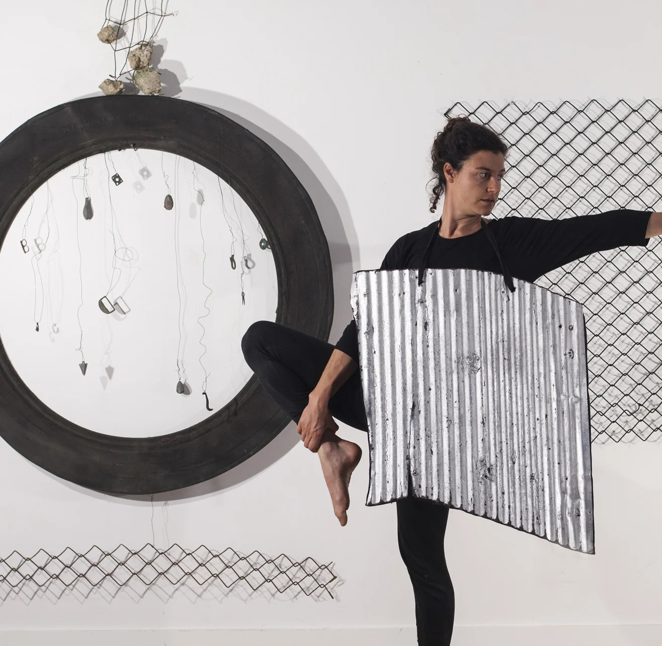 #1040 (Sculpture and Dance Performance): Tire fragment, corrugated metal roofing, chain link fencing, fragment of wire reinforced concrete, small metal objects, daughter. The installation is 8’ tall, 10’ wide and 3’ deep.