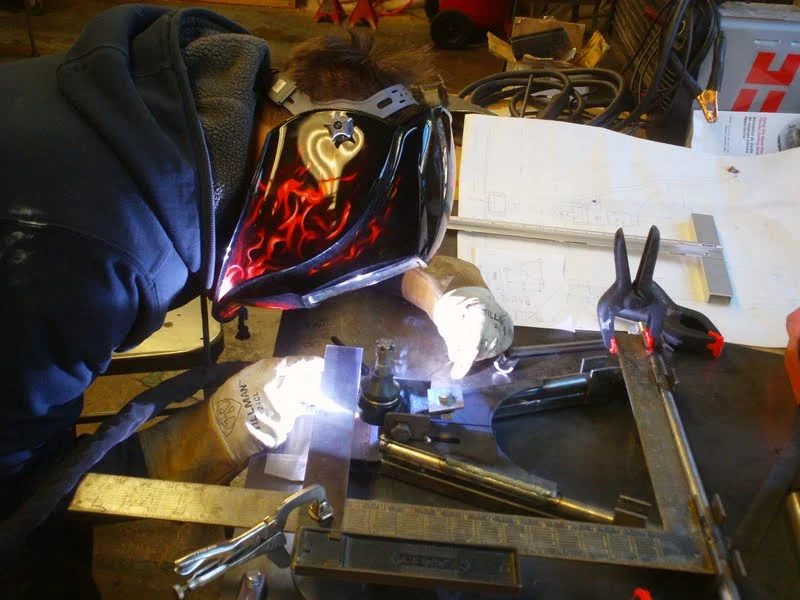 Mr.G TIG welding a custom designed a arm. The arm was attached to a Lotus 7 we built at the school.