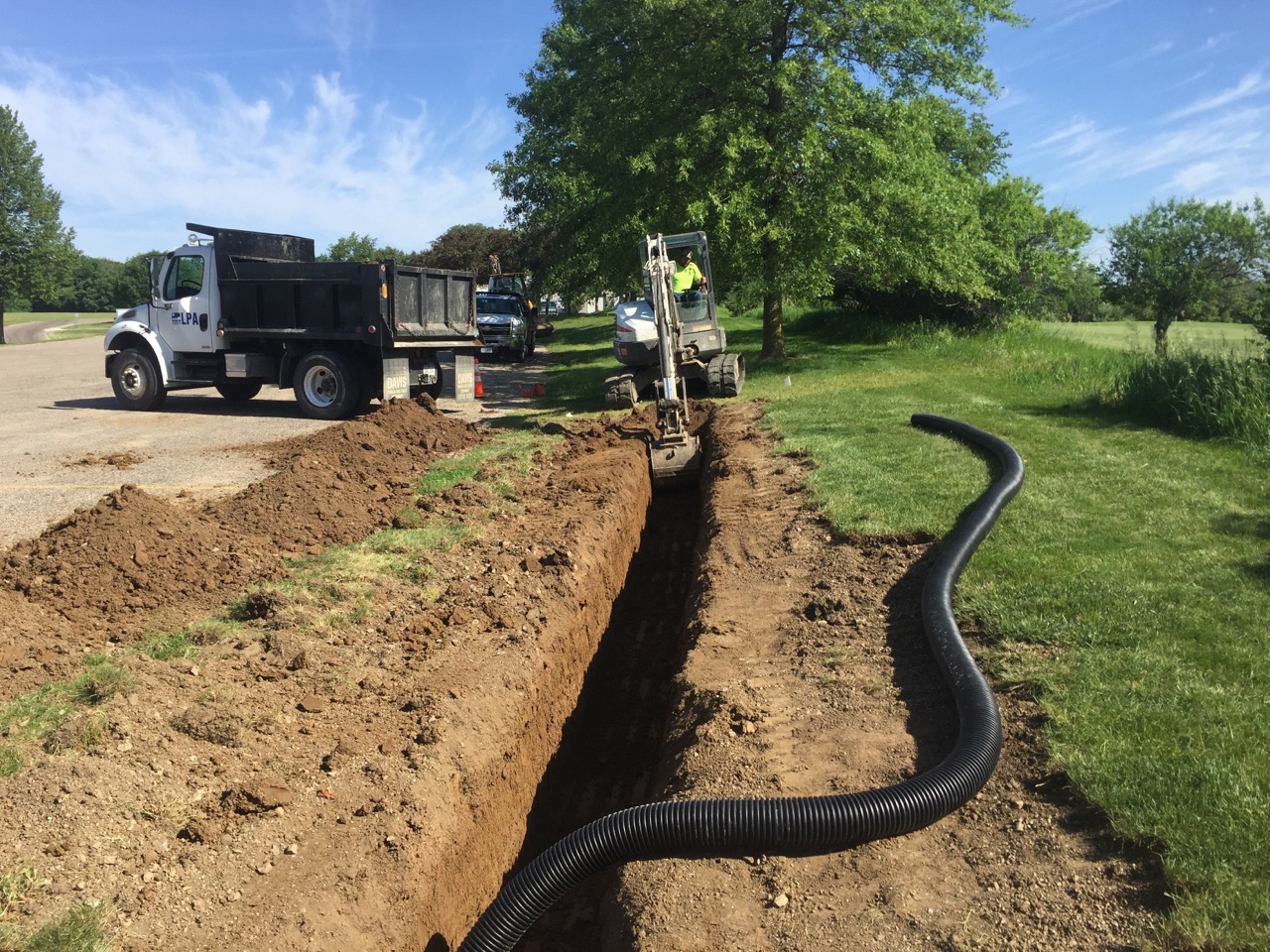 The first step to preparing the rain garden site was to dig a trench for a drain tile to connect to the existing drain. 