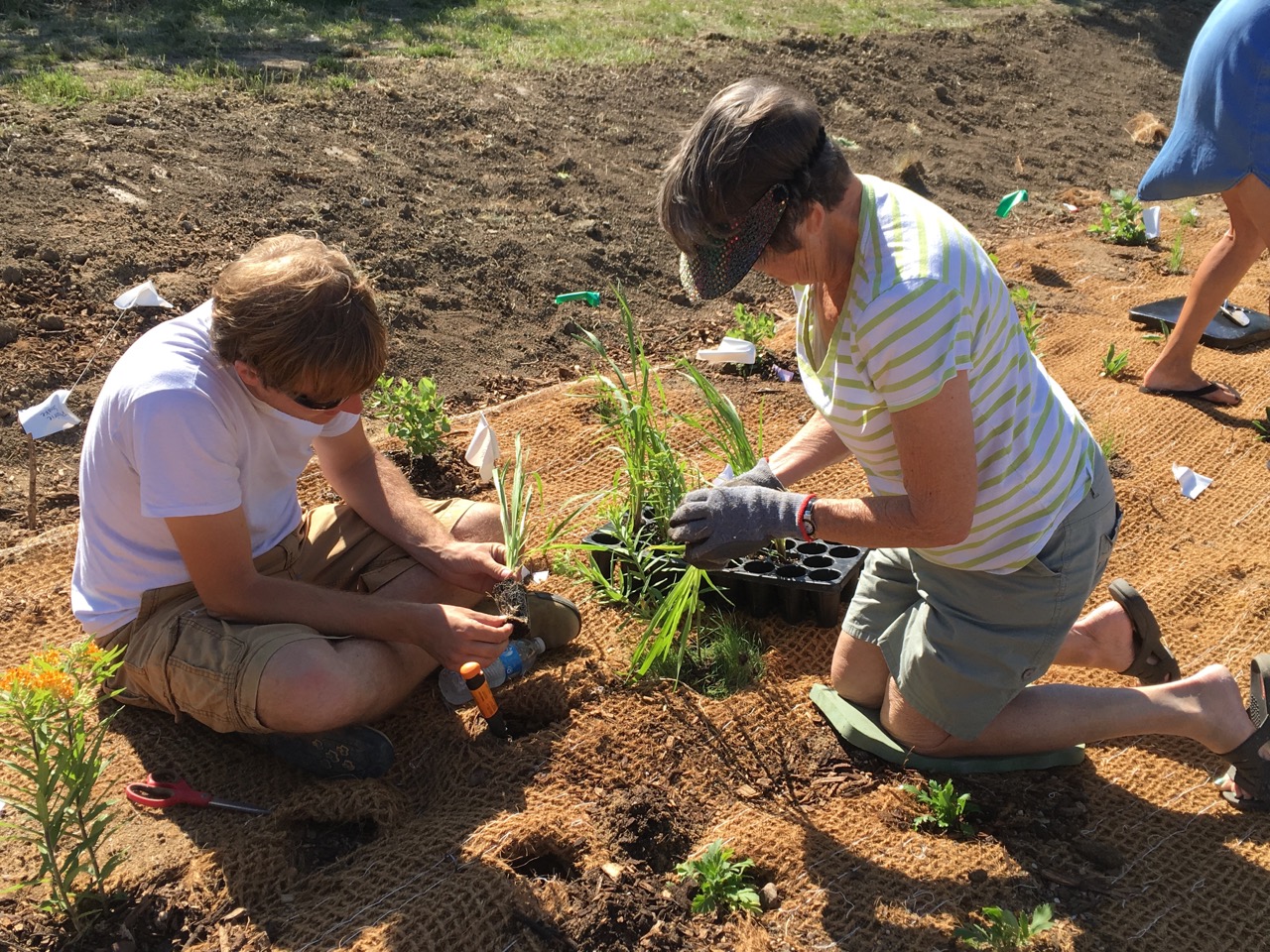 Derek Namanny, an urban conservationist with the Iowa Department of Agriculture and Land Stewardship, designed the rain garden and provided assistance throughout the development process. He also pitched in to help with the planting, and is shown here with volunteer JoAnn Smith. 