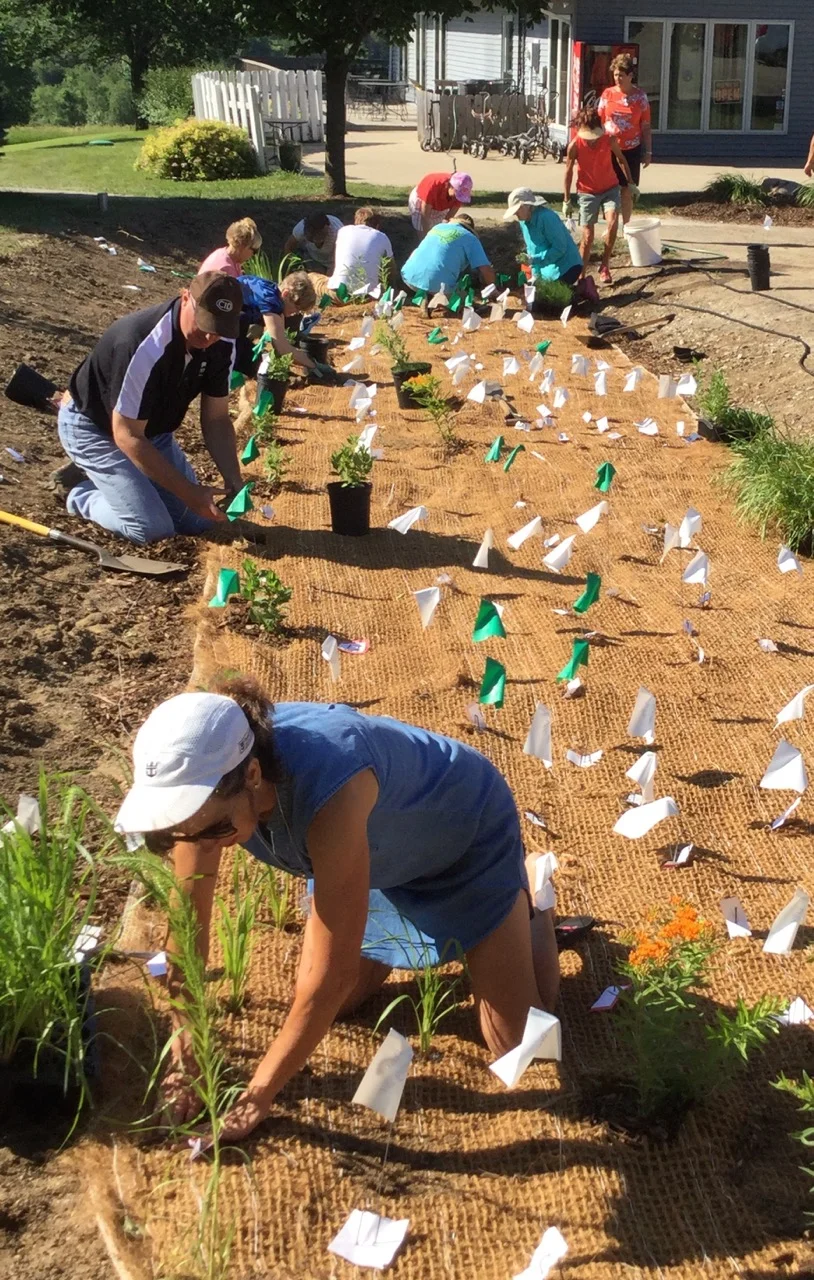Members of the Panora Garden Club were joined by other volunteers to put the rain garden plants into designated spots. Shown in the foreground is Jean Weisz, co-chair of the garden club. 