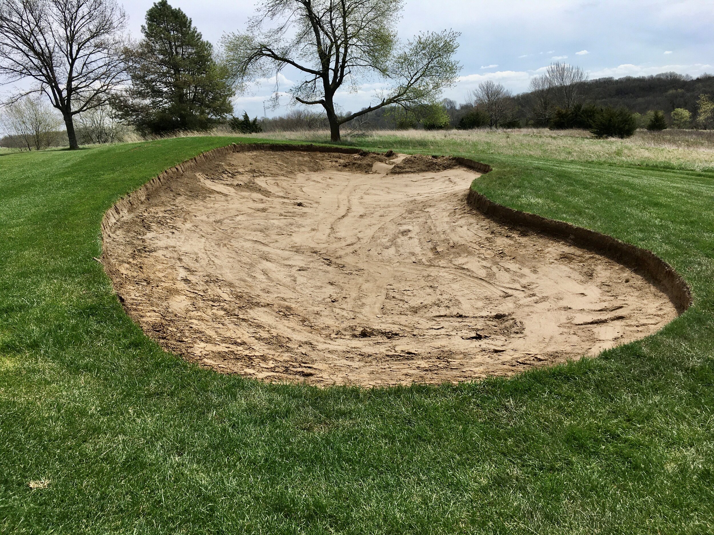 This photo shows the bunker near the eighth green at Panorama West after all existing sand and gravel was removed, and the perimeter outlined with a straight cut. This was before new drainage was installed, followed by new gravel, a two-inch layer o
