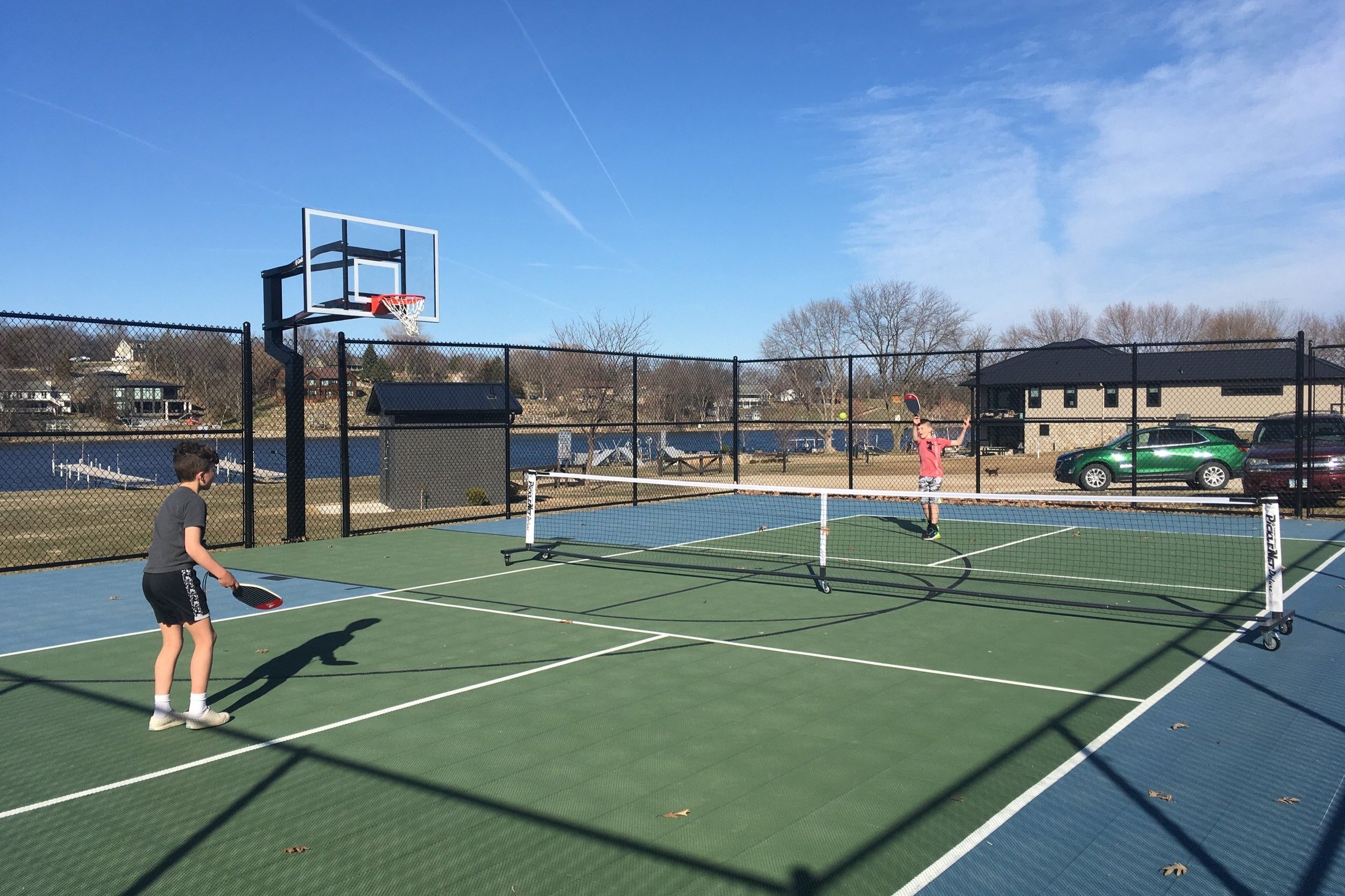 A portable pickleball net is a part of the new Sunset Beach sports court. The fully assembled net is on wheels, and can be stored along the fence when not in use, then rolled into place as needed.