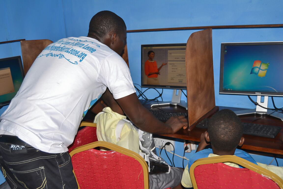 Our IT manager/computer trainer Kemoh Tarawally with teaching school kids