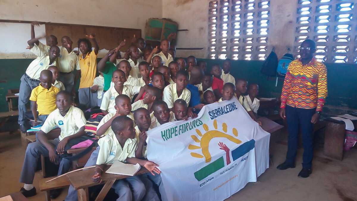 Boys class with hand painted banner of the Hope for Lives logo