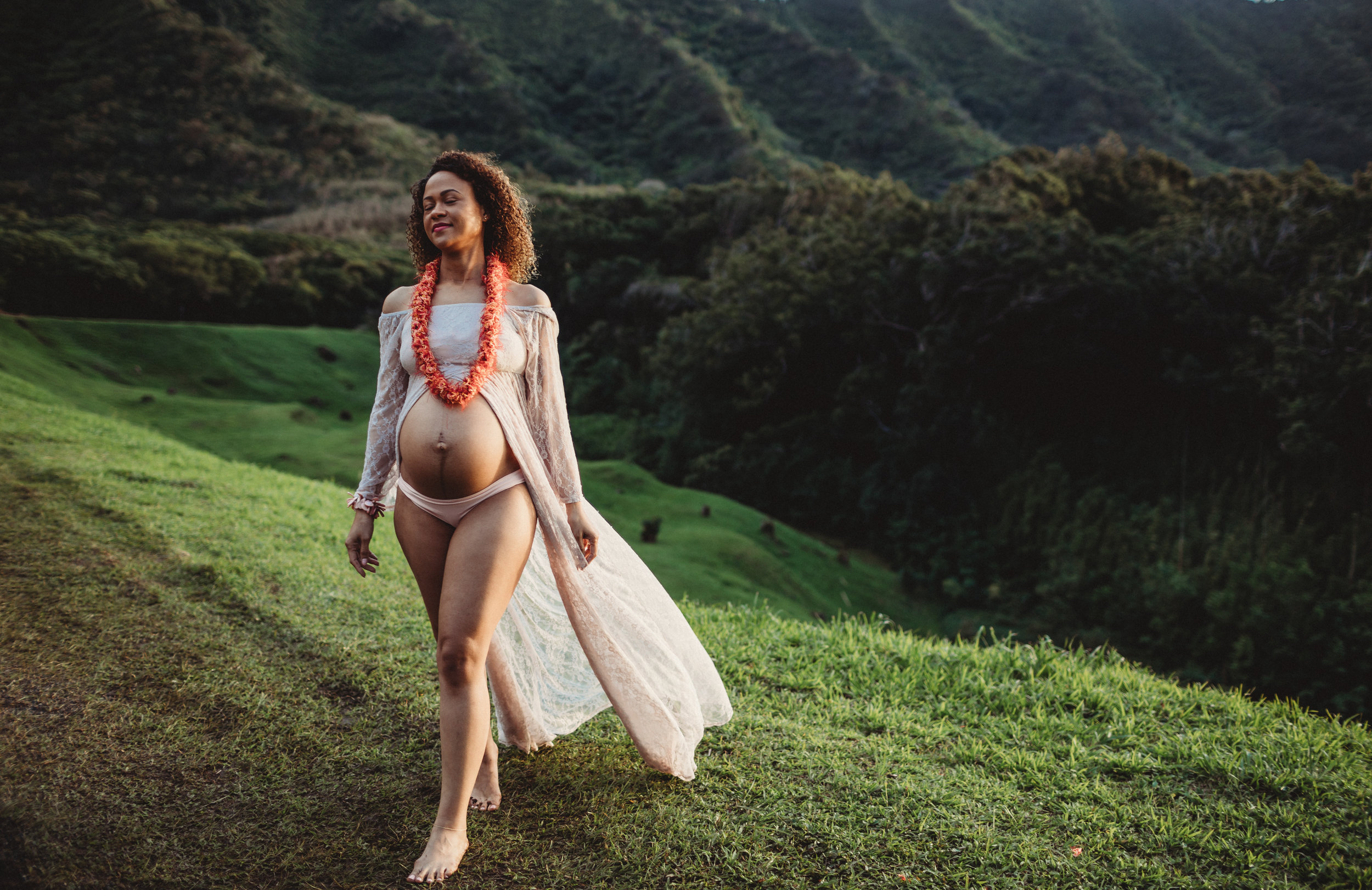  beautiful pregnant woman on the side of a mountain in hawaii  
