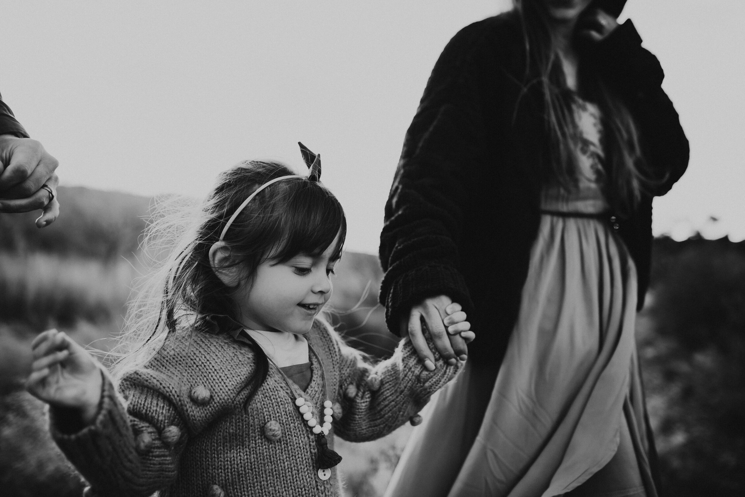  black and white image of a daughter holding her mother’s hand 