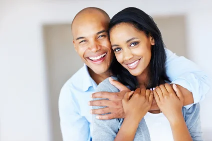 A smiling couple hugging indoors. Dallas therapist Dr. Jada Jackson offering therapy and wellness support.