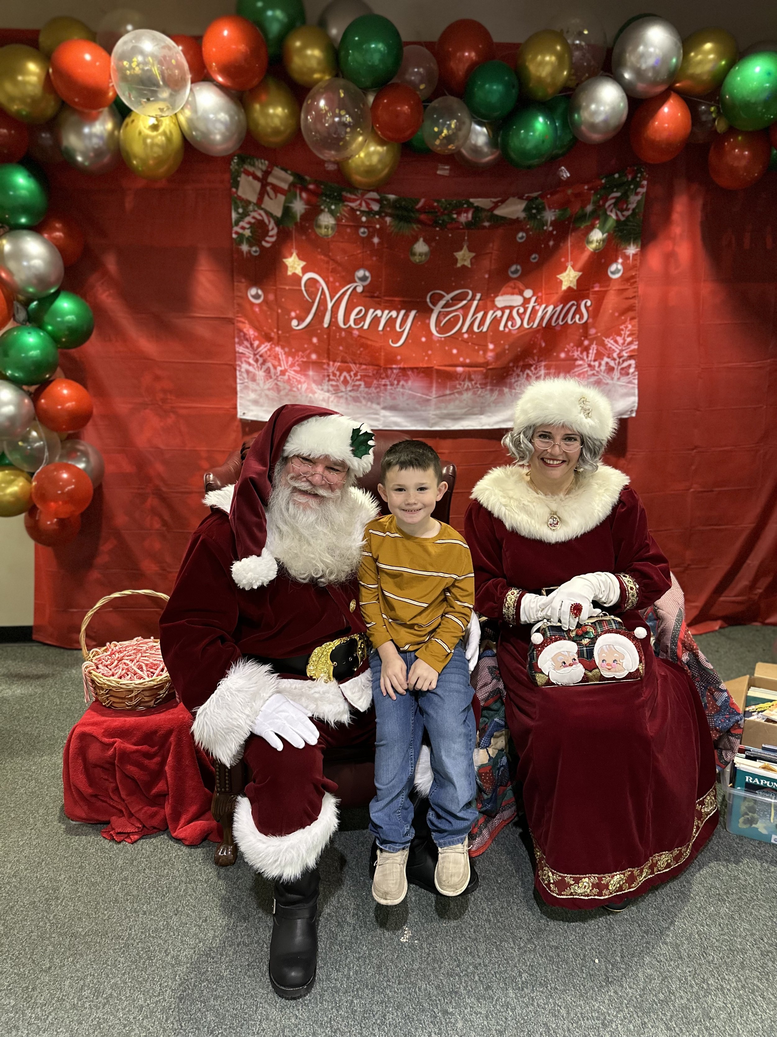Maddox with Santa and Mrs. Claus.jpeg