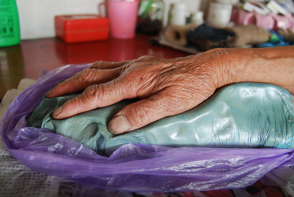 I sculpt the dominant hand, which is the primary working hand. To form a clear outline on the template, I press the clay between the fingers and around the edge of the palm and wrist.