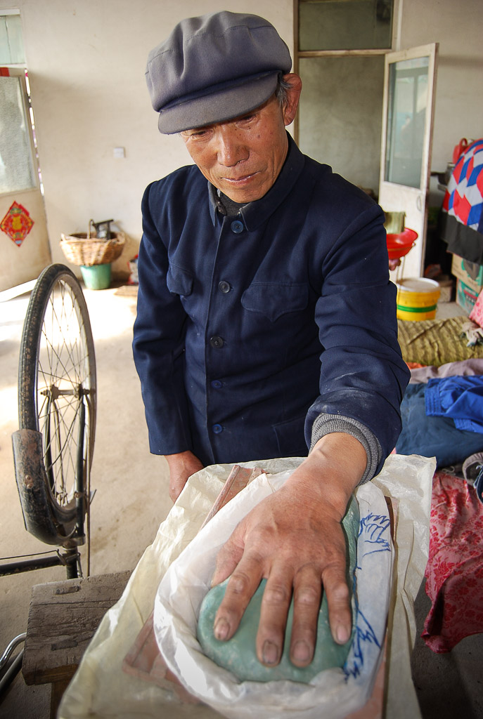 Niu Rong presses his left (dominant) hand into a clay slab to form the template. 
