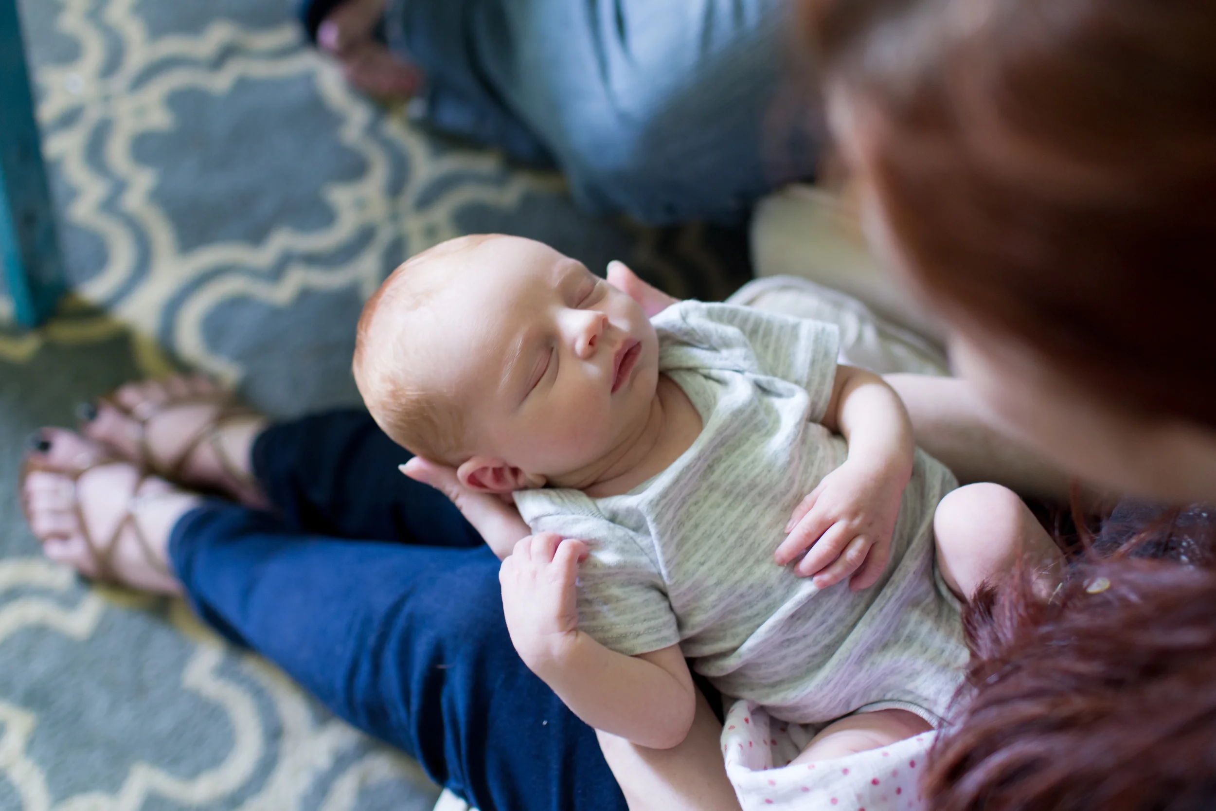 Lifestyle newborn photograph with mother holding sleeping baby boy