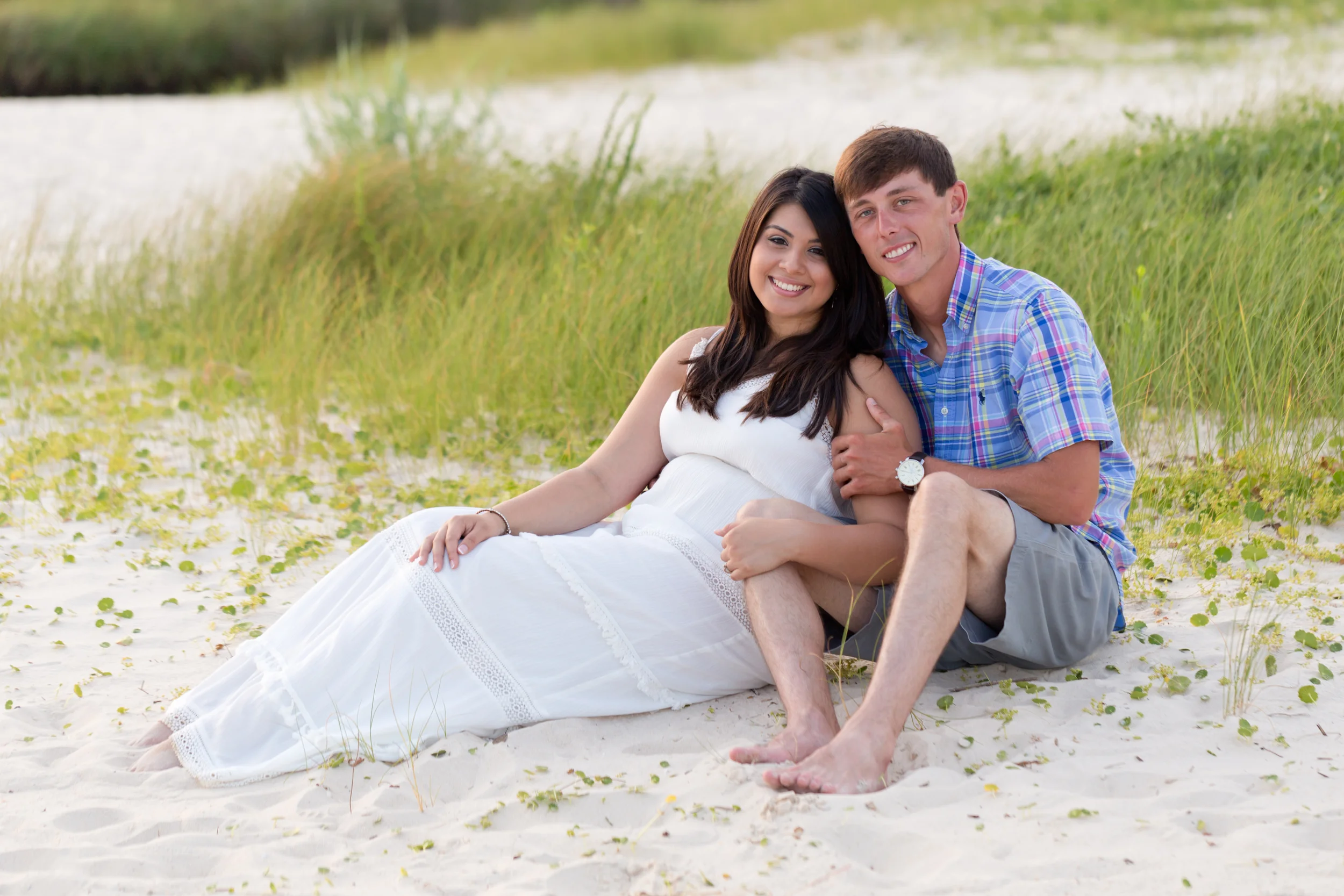 Beautiful young couple seated on East Beach, Ocean Springs, Mississippi