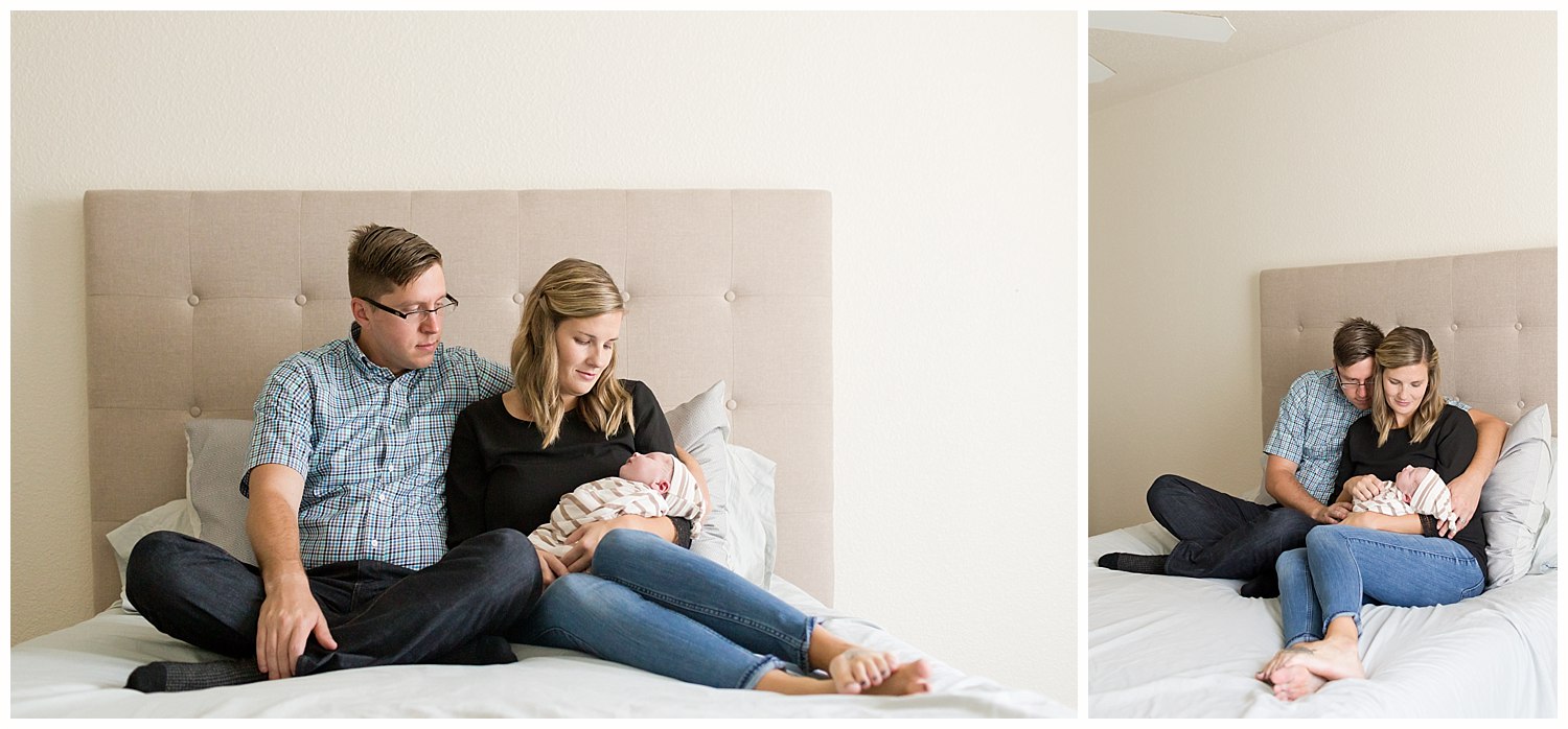 parents snuggled on bed with new baby boy