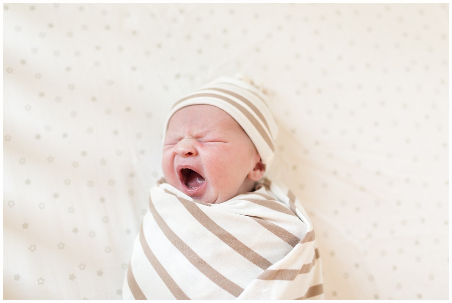 baby boy yawning in crib - lifestyle newborn photos in Bilxoi, MS