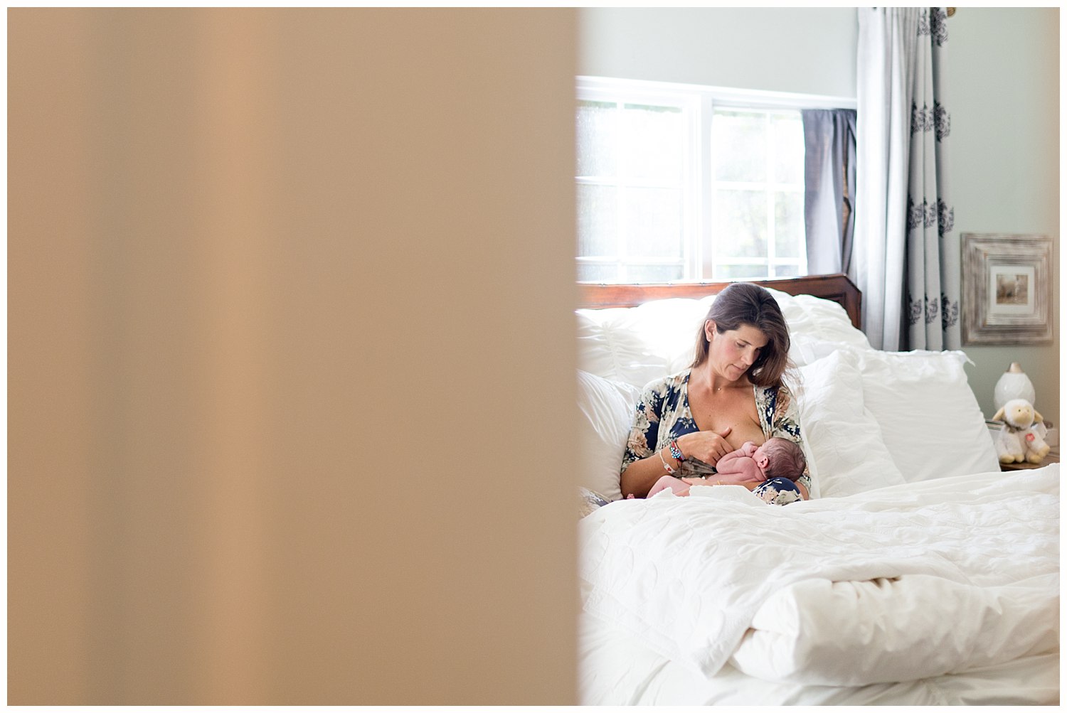 mom nursing baby girl on bed