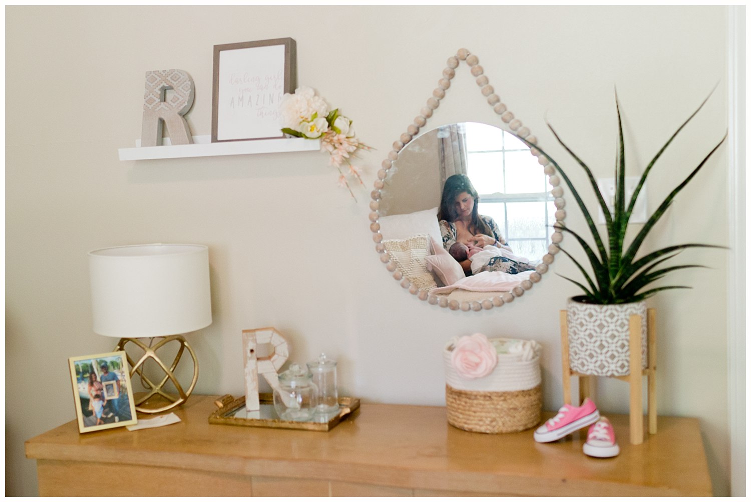 mother nursing baby girl in nursery - mirror reflection with cute decor