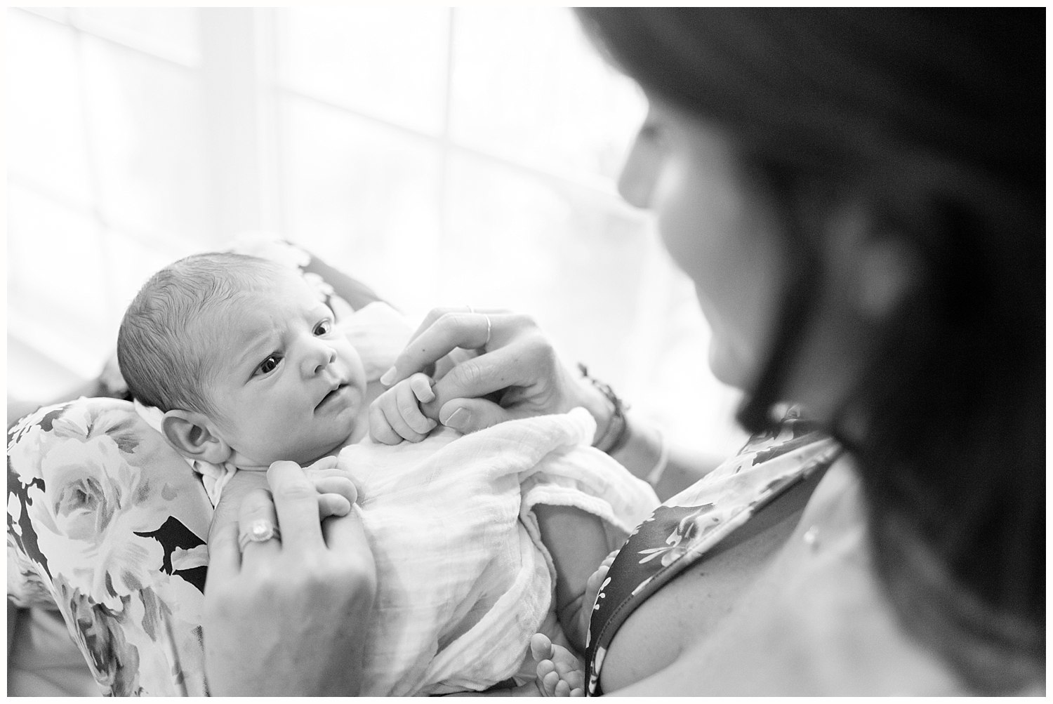 mom playing with alert newborn baby