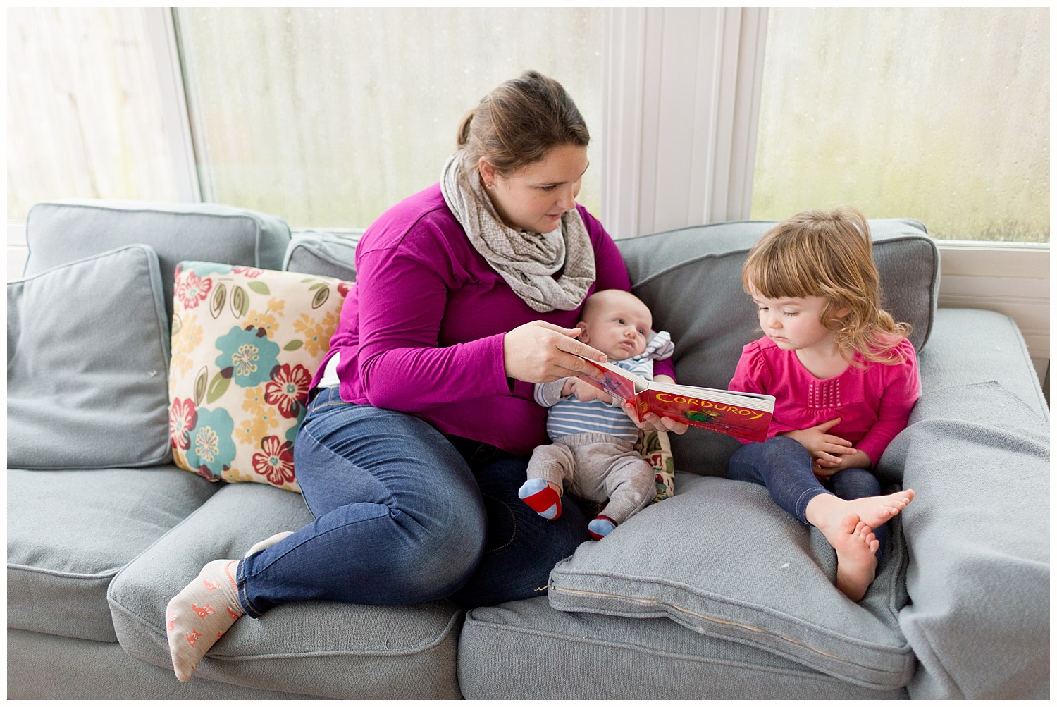 mom reading Corduroy book to baby boy and toddler girl