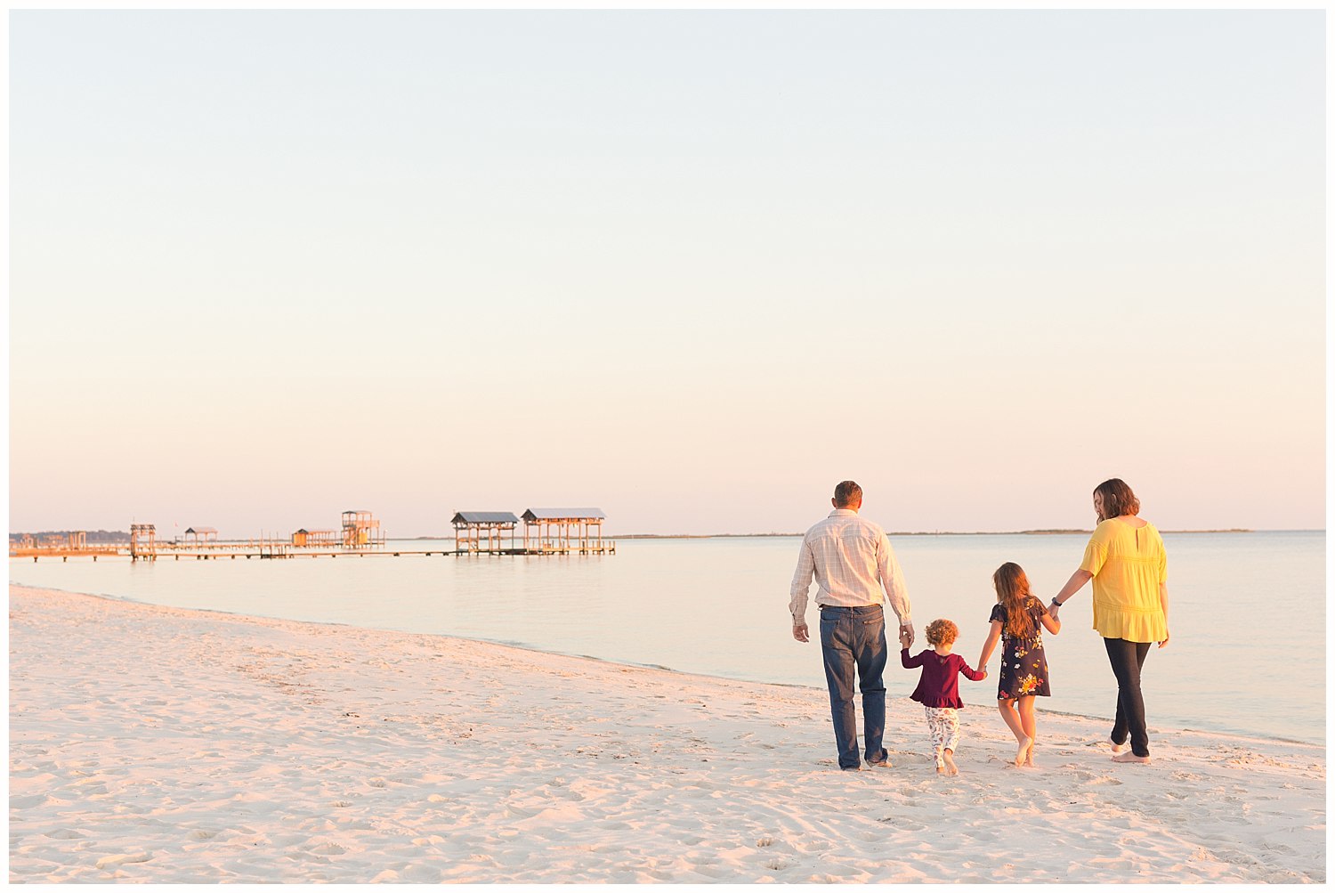 family of four walking on Ocean Springs East Beach