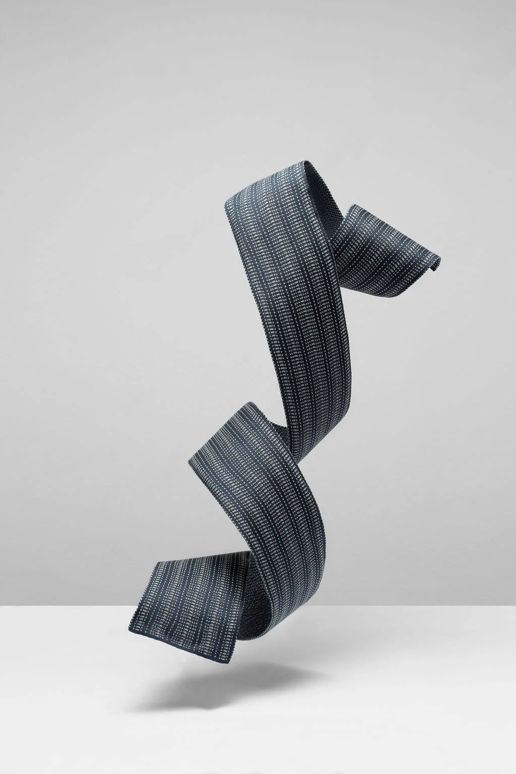 Designer silk scarf for men and women. A dark grey skinny silk scarf, made in Scotland. Scottish Knitwear design by Collingwood-Norris