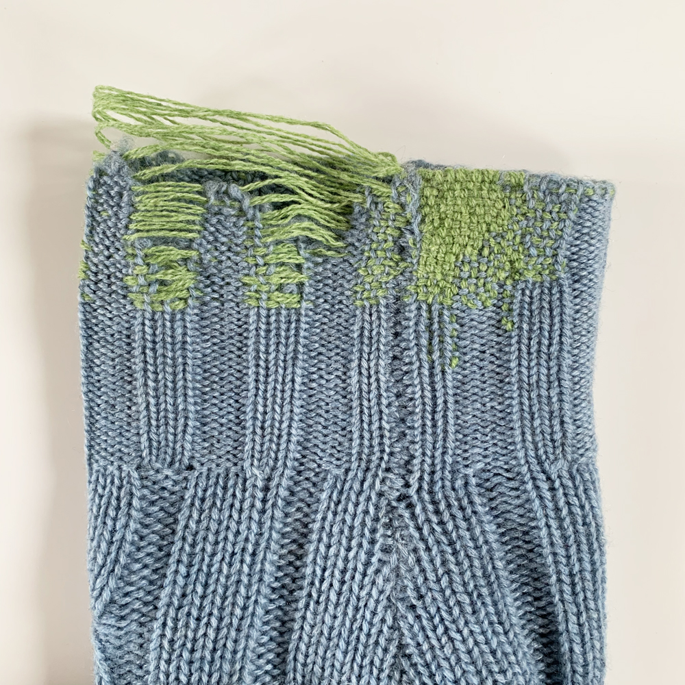 Side view of the long strands of yarn at the top of the cuff.