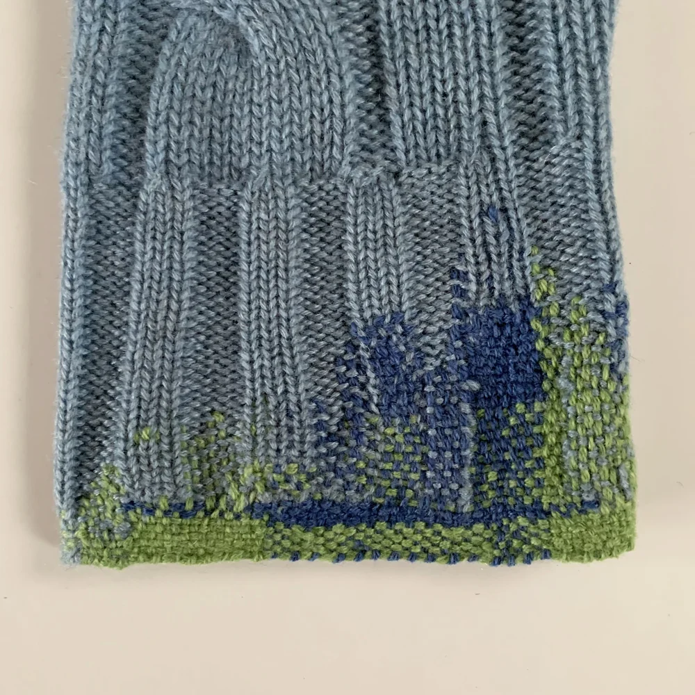 The second cuff. Even though I was very careful with my tension, I still ended up with a loose area between the knitted fabric and my darned edge, so I decided to add some extra weave in, in blue to sort it out. I didn’t like it in the end though- it wasn’t as subtle as I would have liked, so I undid it and worked it in green instead.