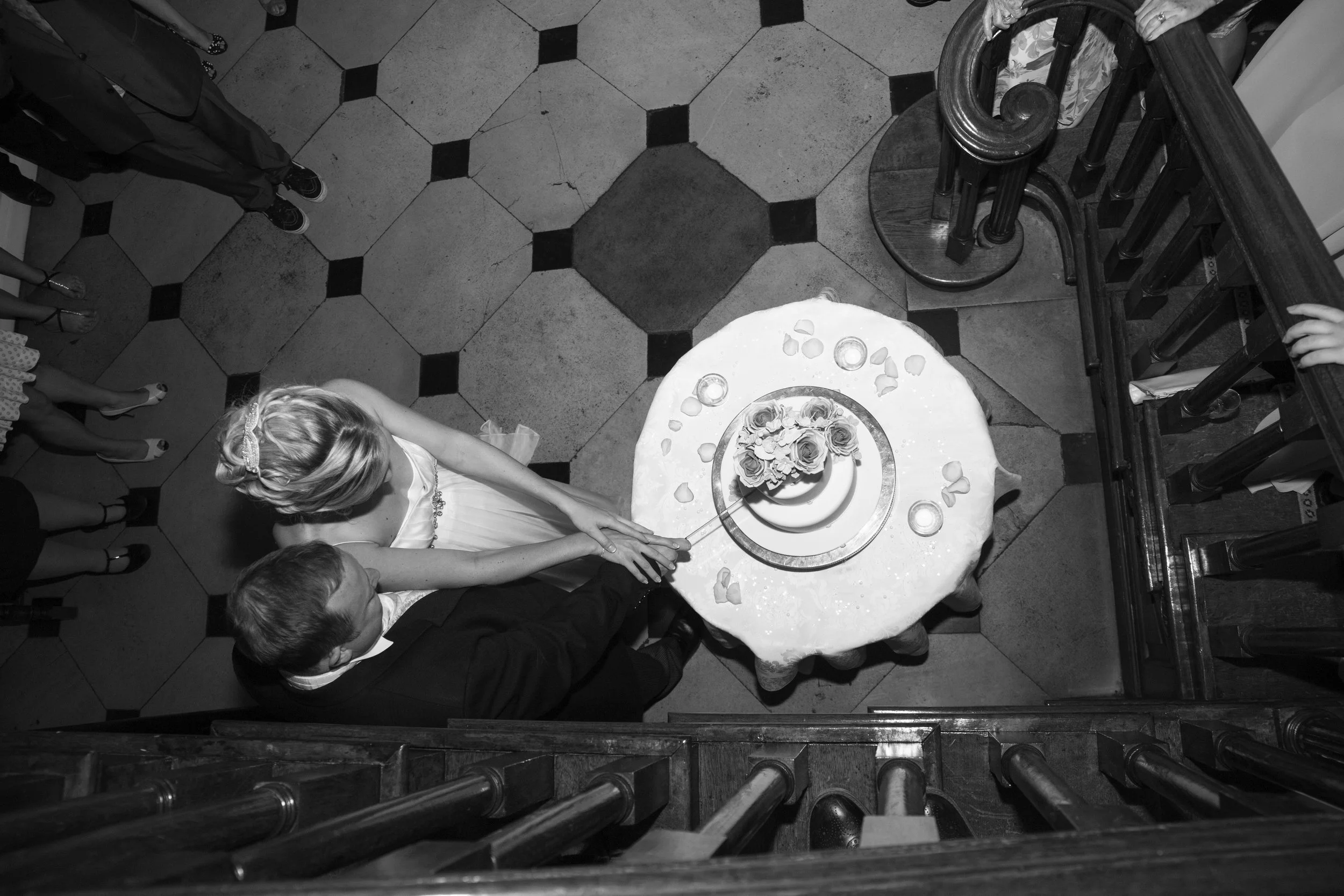 A bride and groom cutting a wedding cake together at a wedding reception.