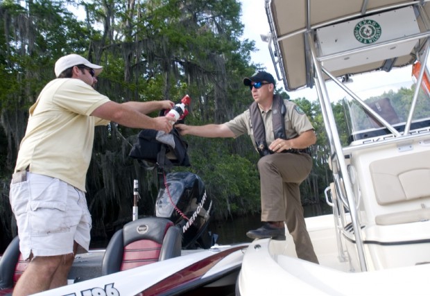 Game Warden Todd Long inspects boating equipment Thursday belonging to Owen Windham of Benton, La., while patrolling on Caddo Lake..jpg