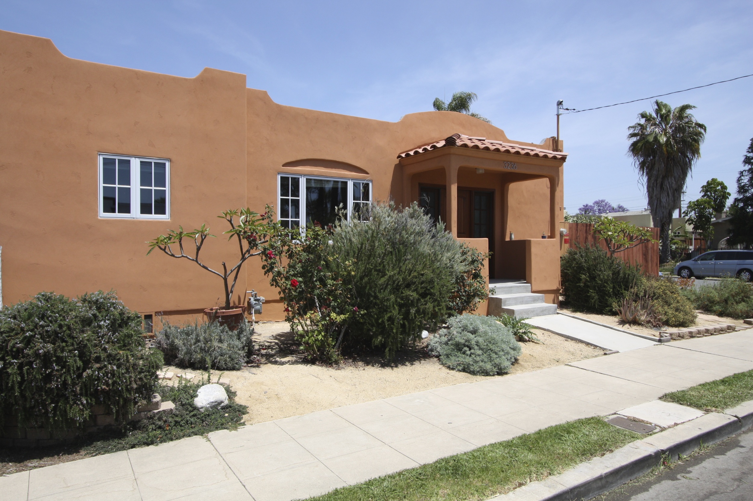  After: New stucco in a terra cotta color and new clay tiles on porch roof really compliment the style of the house. 